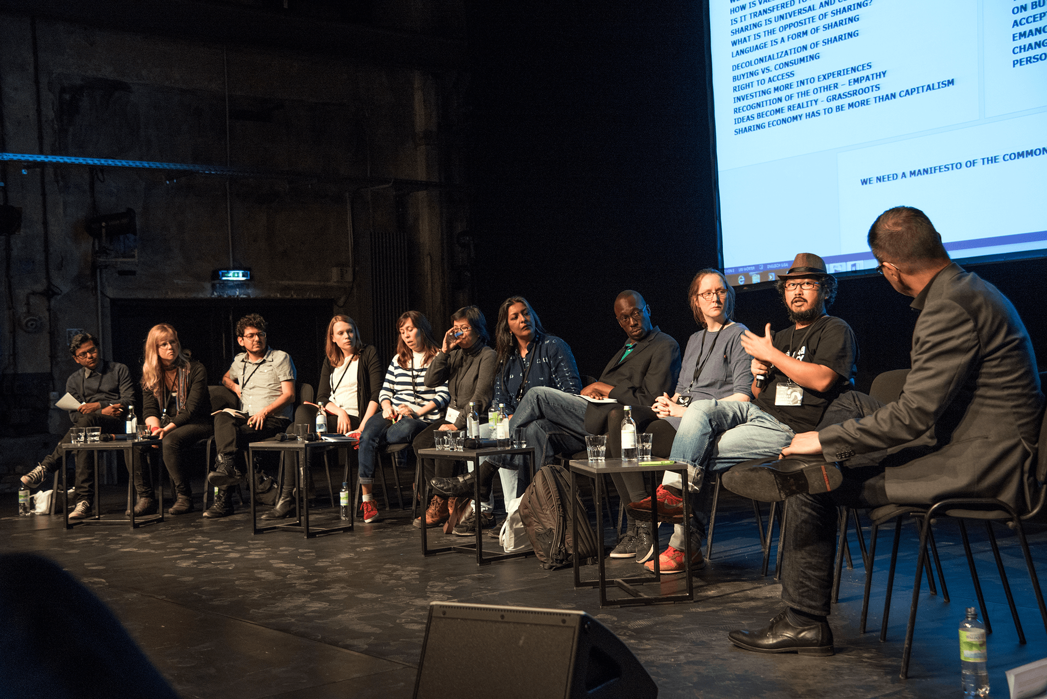 Podiumsdiskussion auf einer Bühne mit digitaler Leinwand / Panel discussion on a stage with digital screen
