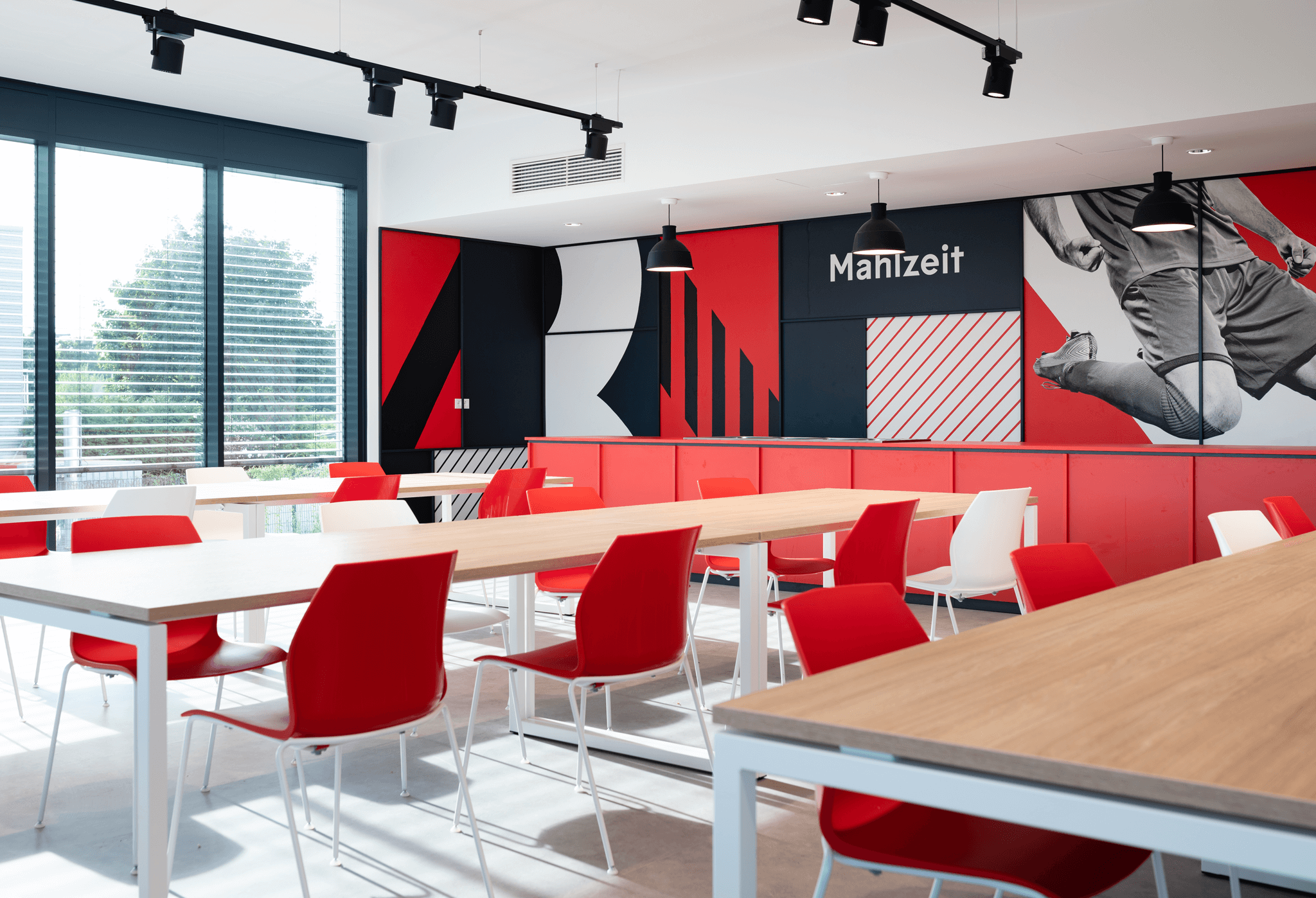 Canteen showing red and white branded furniture, chairs, tables and wall decoration
